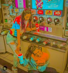 two young women standing in front of a vending machine with sodas on it