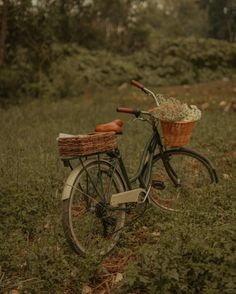 an old bicycle with a basket is parked in the grass