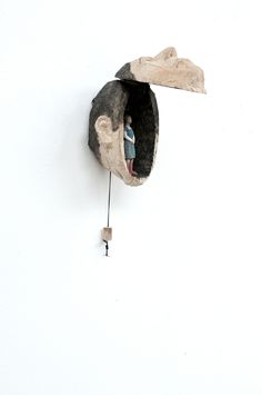 a clock with a man's head hanging on the wall next to a key