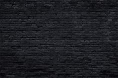 an old black brick wall is shown in this image