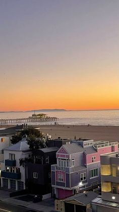 the sun is setting over some colorful houses by the beach in san francisco, california