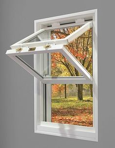 an open window with fall leaves outside it and trees in the backgrounge