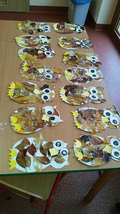 a table topped with lots of paper plates covered in leaves and eyeballs on them