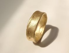 a close up of a gold ring on a white surface