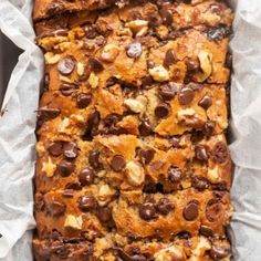 a loaf of chocolate chip banana bread on top of some white paper in a pan