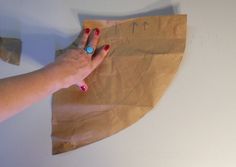 a woman's hand holding onto a piece of brown paper