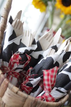 a basket filled with forks and napkins on top of a table next to sunflowers