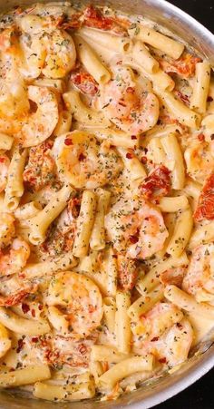 a pan filled with pasta and shrimp covered in sauce