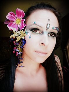 a woman with makeup and flowers in her hair