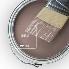 a paint can with a brush in it and labeled cougar on the side