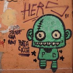 graffiti on the side of a building with a green zombie face and words written below it