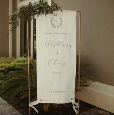 a white wedding sign sitting in front of a building