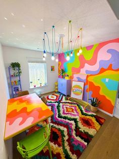 a brightly colored room with colorful rugs on the floor and tables in front of it