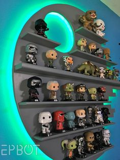 star wars action figures are displayed on shelves in a room with blue walls and green lighting