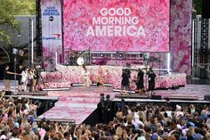 a group of people standing on top of a stage in front of a large crowd