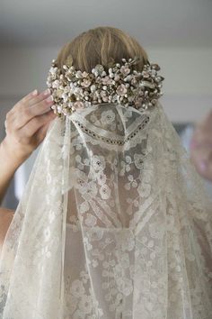 a woman wearing a veil with flowers on it