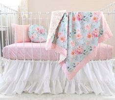 a white crib with pink and blue flowers on it