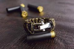 a close up of a bracelet on a table with two lighters in the background