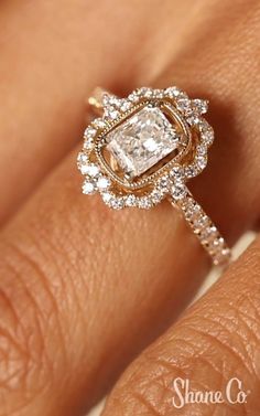 a woman's hand with an engagement ring on it and the center stone is surrounded by diamonds