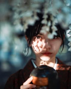 a young woman holding a vase in front of her face