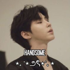 a man with his eyes closed standing in front of a sign that says handsome and has five stars on it