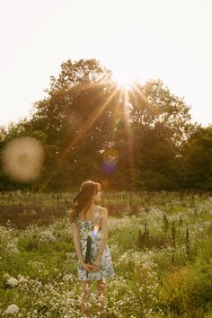 a woman standing in the middle of a field