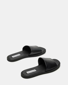 CHILL + SLEEK + CLEAN A monochrome design and a wide strap gives the flat KAYA slide its classic look. Slide sandal Slip-on style .5 inch heel height Leather upper material Synthetic lining Synthetic sole Imported Designer Slides Women, Europe 2024, Steve Madden Store, Black Slides, Monochrome Design, Slides Women, Leather Slide Sandals, 5 Inch Heels, Leather Slides