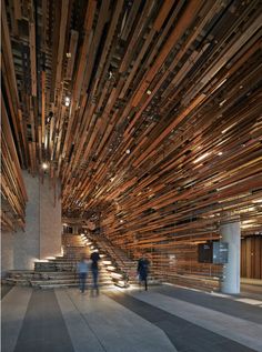 two people are walking up some stairs made out of wooden planks and wood slats