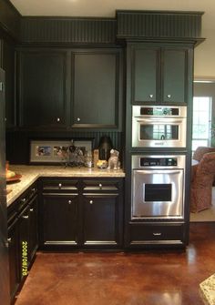 a kitchen with black cabinets and stainless steel appliances