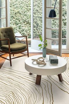 a living room filled with furniture and a white coffee table in front of an open window