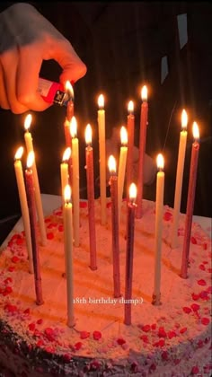 someone is lighting candles on a birthday cake