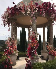 a gazebo covered in lots of pink and white flowers