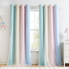 a room with a white dresser and colorful curtains