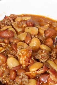 a white bowl filled with beans and meat