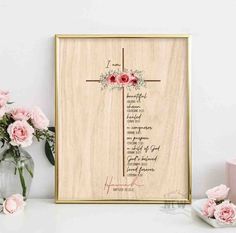 a wooden cross with flowers on it next to some candles and pink carnations