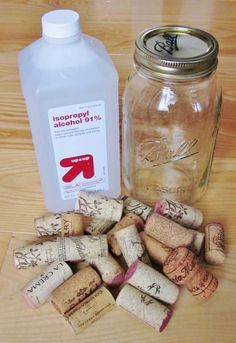 several wine corks and a bottle of alcohol on a wooden table next to it