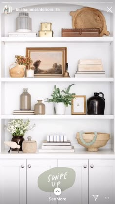 a white book shelf with books and vases sitting on it's top shelves