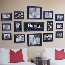 a living room filled with white couches and pictures on the wall above them that say family