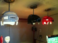 three lights are hanging from the ceiling in a room with two televisions and other items