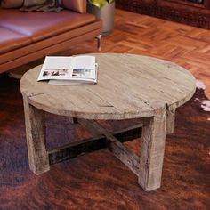 a wooden table sitting on top of a hard wood floor next to a purple couch