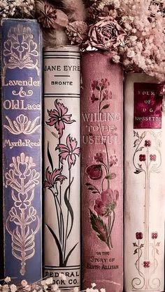 four books are lined up next to each other with flowers on the covers and in between them