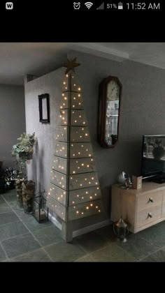 a living room with a small christmas tree on the wall and lights strung from it