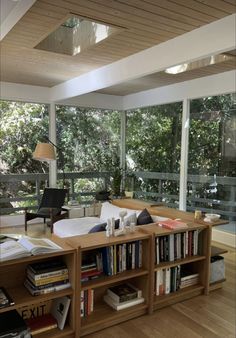 a living room filled with furniture and lots of books on top of a hard wood floor