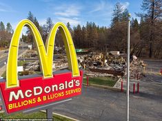 a large mcdonald's sign in front of a building that has been burned down