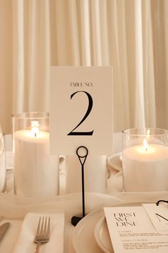 a table set for two with candles and place cards