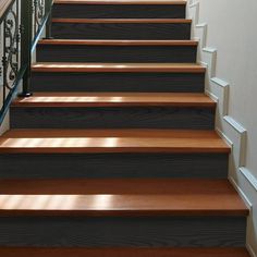 a set of stairs with wood treads and wrought iron balconies on either side