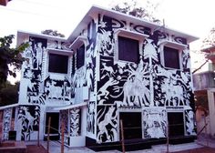 an artistic building is painted with black and white designs on the outside, along with other buildings