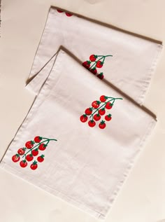 two white napkins with cherries on them