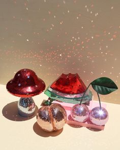 three disco balls and a plant in front of a wall with glitters on it