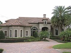 a large house with lots of windows and palm trees